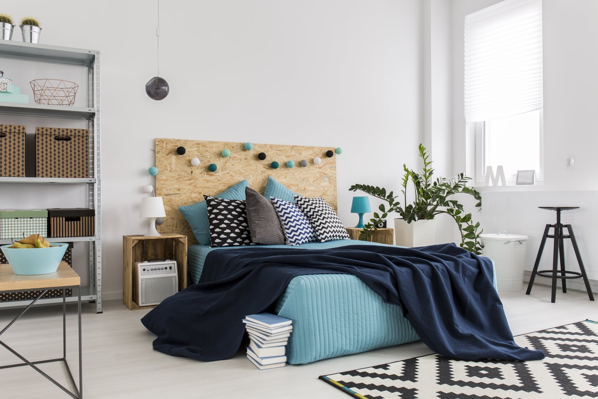 bedroom with blue bedspread and industrial shelves