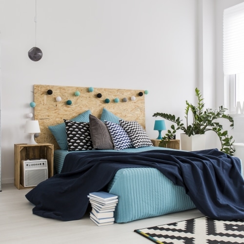 bedroom with blue bedspread and industrial shelves